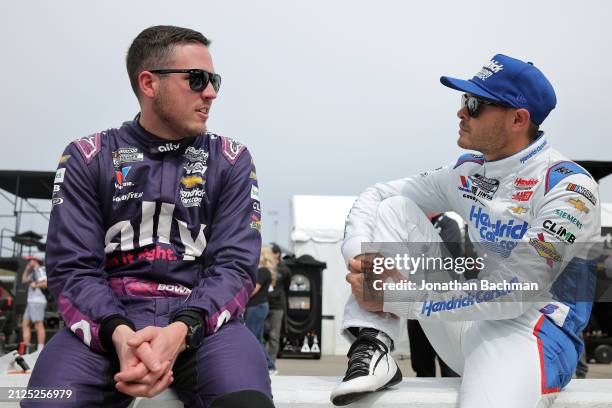 Alex Bowman, driver of the Ally Chevrolet, and Kyle Larson, driver of the HendrickCars.com Chevrolet, talk on the grid during qualifying for the...