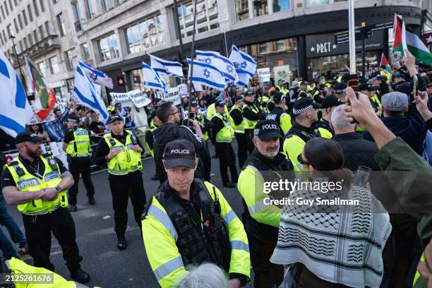 Lines of police keep the Ceasefire Now protest and the pro-Israel counter demonstration apart on March 30, 2024 in London, England. Thousands...