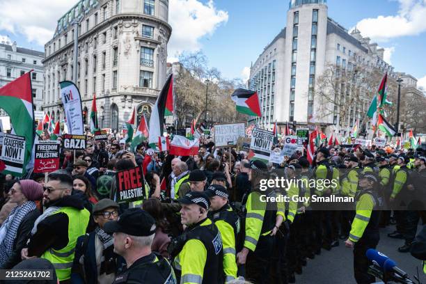 Lines of police keep the Ceasefire Now protest and the pro-Israel counter demonstration apart on March 30, 2024 in London, England. Thousands...