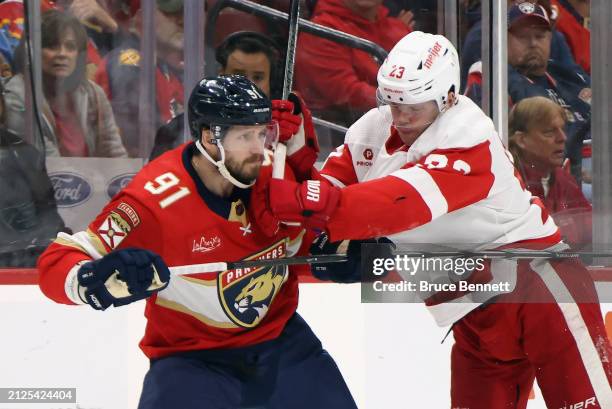 Lucas Raymond of the Detroit Red Wings gets the stick up on Oliver Ekman-Larsson of the Florida Panthers during the first period at Amerant Bank...