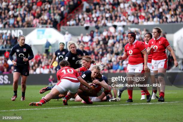 Rosie Galligan of England scores her team's seventh try whilst under pressure from Lleucu George and Georgia Evans of Wales during the Guinness...