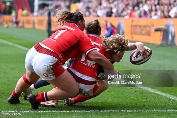 Ellie Kildunne of England scores her team's fifth try whilst being tackled by Gwenllian Pyrs and Jenny Hesketh of Wales during the Guinness Women's...