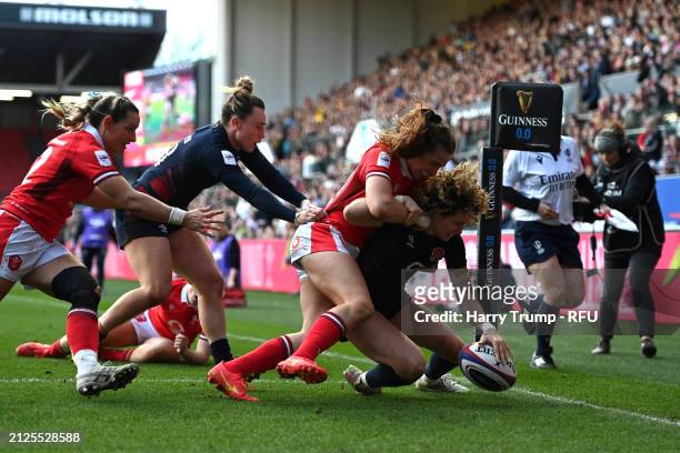 Ellie Kildunne of England scores her team's eighth try whilst being tackled by Lisa Neumann of Wales during the Guinness Women's Six Nations 2024...