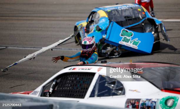 Joey Gase, driver of the NCPC Race Against Crime Chevrolet, throws his wrecked rear bumper cover at Dawson Cram, driver of the TeamJDMotorsports.com...