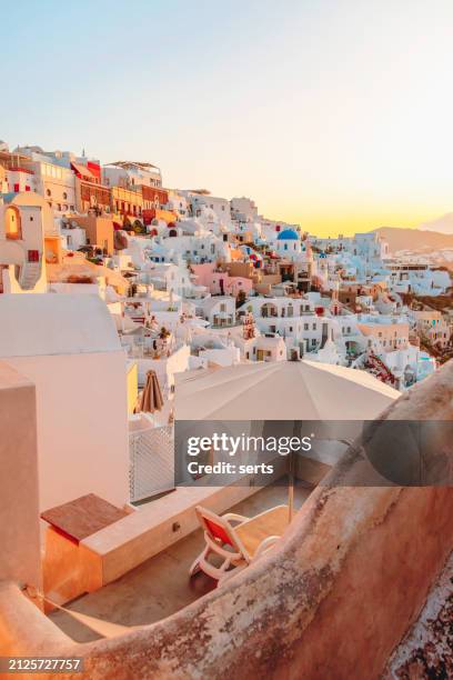 beautiful summer vacation landscape of iconic blue domed churches along the caldera edge at sunny morning against the sun rises over the ocean in oia, santorini, caldera, greek islands, greece - mediterranean-blue-roof-santorini stock pictures, royalty-free photos & images