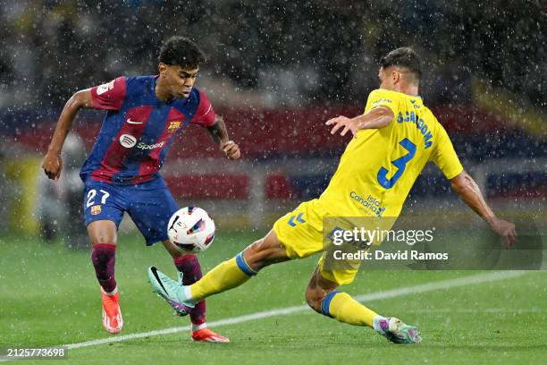 Lamine Yamal of FC Barcelona is challenged by Sergi Cardona of UD Las Palmas during the LaLiga EA Sports match between FC Barcelona and UD Las Palmas...