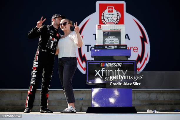 Chandler Smith, driver of the Mobil 1 Toyota, and wife, Kenzie Smith celebrate in victory lane after winning the NASCAR Xfinity Series ToyotaCare 250...