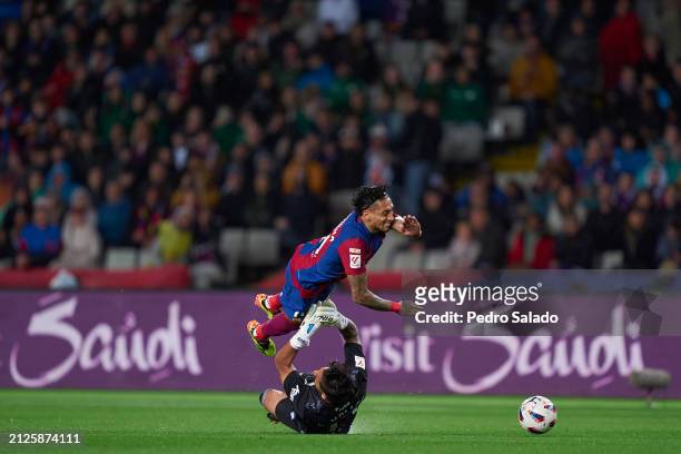 Alvaro Valles of UD Las Palmas tackles Raphinha of FC Barcelona during the LaLiga EA Sports match between FC Barcelona and UD Las Palmas at Estadi...