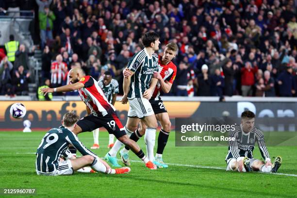 Scott McTominay, Harry Maguire and Mason Mount of Manchester United look dejected after Kristoffer Ajer of Brentford scores his team's second goal...