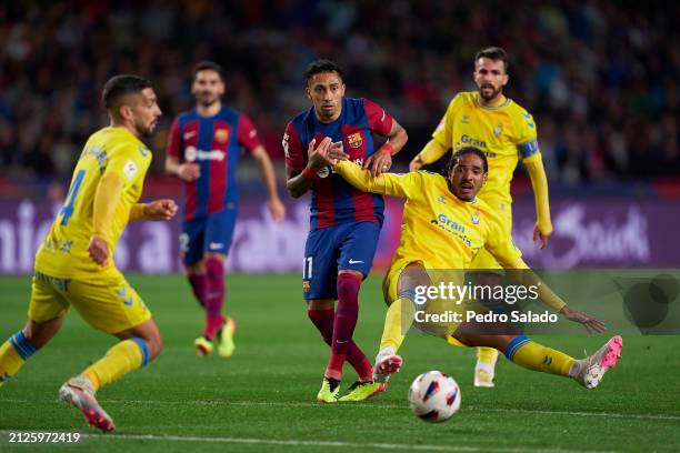 Raphinha of FC Barcelona competes for the ball with Saul Coco of UD Las Palmas during the LaLiga EA Sports match between FC Barcelona and UD Las...