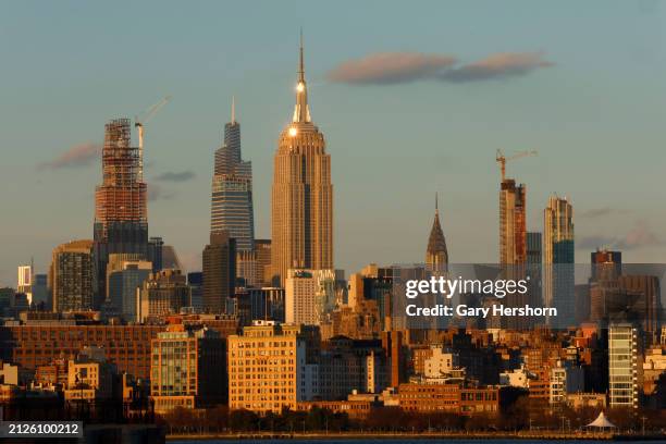 The sun sets on the skyline of midtown Manhattan and the Empire State Building in New York City on March 29 as seen from Jersey City, New Jersey.