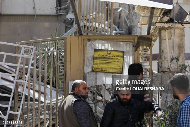 People wait outside a building annexed to the Iranian embassy a day after an air strike in Damascus on April 2, 2024. Iran warned arch foe Israel on...