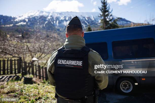 French gendarme stands guard near the French southern Alps tiny village of Le Haut-Vernet, in Le Vernet on April 2 two days after French...