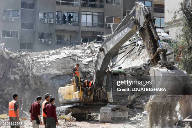 Rescue workers search in the rubble of a building annexed to the Iranian embassy a day after an air strike in Damascus on April 2, 2024. Iran warned...