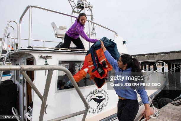 Morgan Pirozzi , a photo intern, and Shreya Vinodh, a habitat intern, load gear onto the R/V Shearwater before a research cruise to study Right...