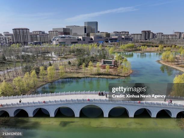 An aerial drone photo taken on March 29, 2024 shows people enjoying themselves at Jinhu park in Xiong'an New Area in north China's Hebei Province. In...