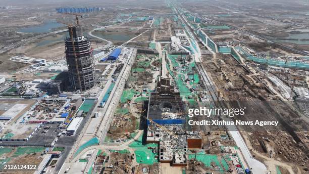 An aerial drone photo taken on March 29, 2024 shows an inter-city railway station and an international trade center in Xiong'an New Area, north...