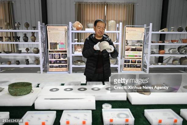 Lei Jianhong, head of the archaeologist group from the Hebei provincial institute of cultural relics and archaeology, arranges cultural relics of the...