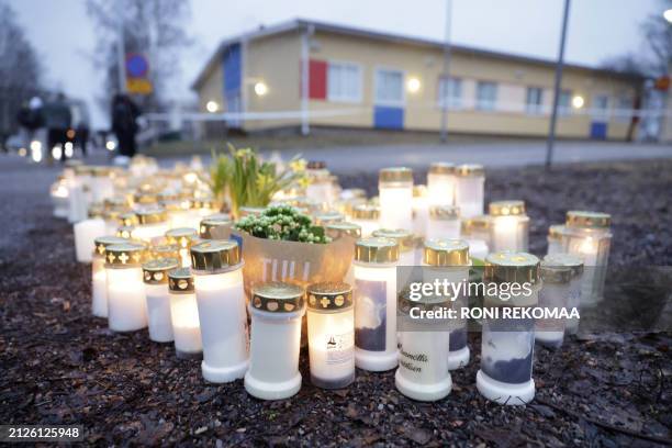 Candles and flowers placed on a square in front of the Viertola School to pay tribute to victims are pictured in Vantaa, Finland, on April 2 after a...