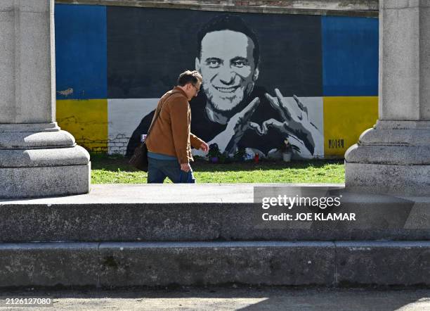 Man walks past a mural dedicated to late Russian opposition leader Alexei Navalny that has been spray-painted on the wall of a property owned by the...