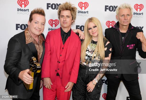 Tré Cool, Billie Joe Armstrong and Mike Dirnt of Green Day, winners of the Landmark Award, pose with Avril Lavigne in the press room during the 2024...