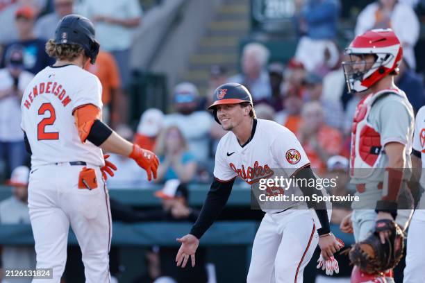 Baltimore Orioles catcher Adley Rutschman congratulates shortstop Gunnar Henderson after his home run during an MLB spring training game against the...