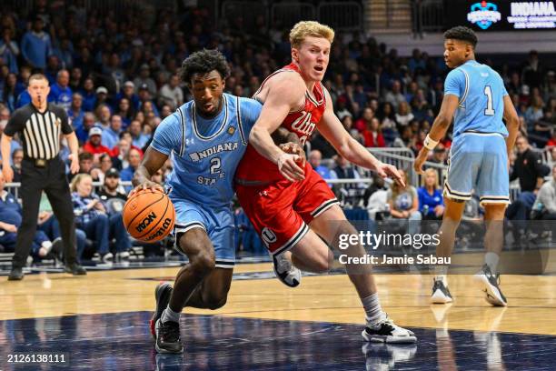 Isaiah Swope of the Indiana State Sycamores strips the ball away from Hunter Erickson of the Utah Utes during the second half of a NIT Semifinals...