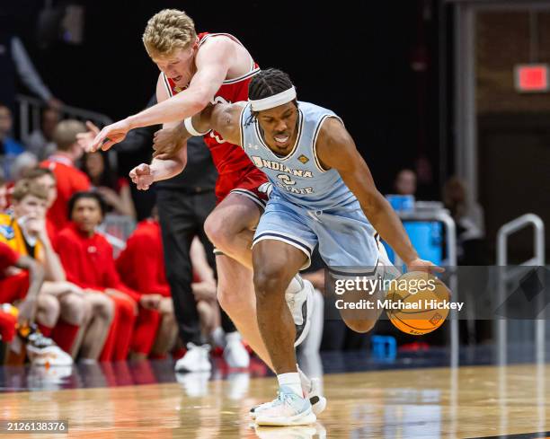 Hunter Erickson of the Utah Utes and Ryan Conwell of the Indiana State Sycamores battle for a loose ball during the second half in the NIT Semifinals...