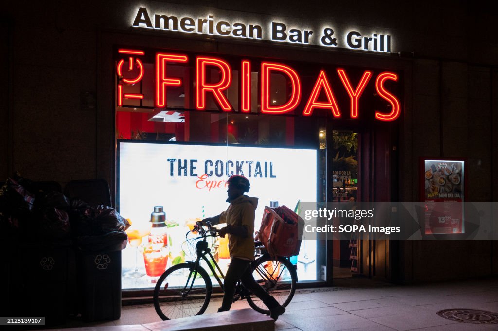 An on-demand delivery worker carrying a bike walks past the...