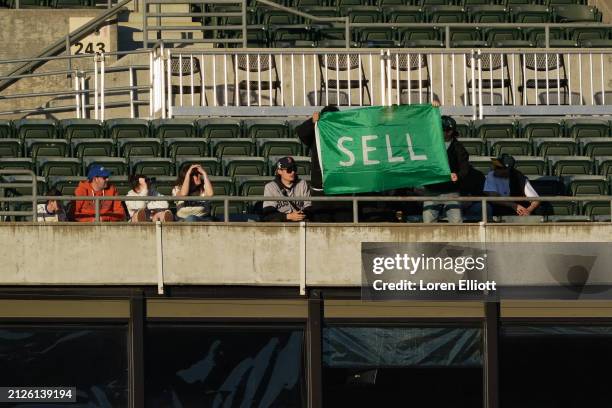 Fans hold up a "SELL" flag as the Boston Red Sox play the Oakland Athletics at Oakland Coliseum on April 02, 2024 in Oakland, California.