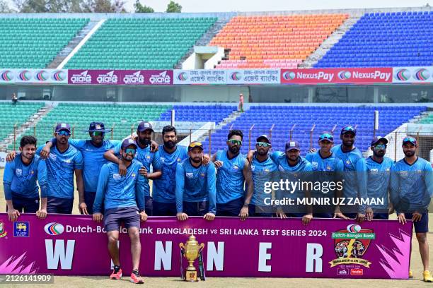 Sri Lanka's players pose with the series trophy after winning the second and last Test cricket match between Bangladesh and Sri Lanka at the Zahur...