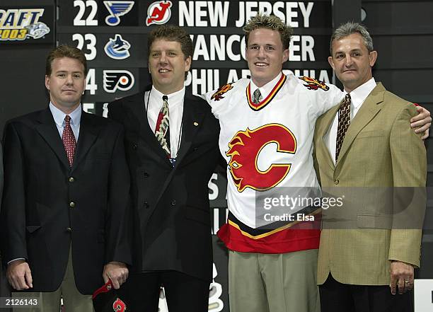 Mike Sands, Tod Button, first round draft pick Dion Phaneuf, and Darryl Sutter of the Calgary Flames pose for a portrait on stage during the 2003 NHL...