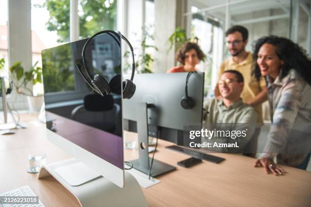 diverse coworkers assisting hispanic male employee to secure a client in a modern call center - customer retention stock pictures, royalty-free photos & images
