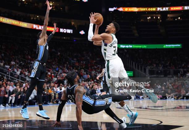 Giannis Antetokounmpo of the Milwaukee Bucks is charged with an offensive foul as he drives into Wesley Matthews of the Atlanta Hawks during the...