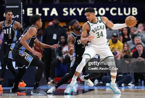 Giannis Antetokounmpo of the Milwaukee Bucks drives against Wesley Matthews and De'Andre Hunter of the Atlanta Hawks during the third quarter at...