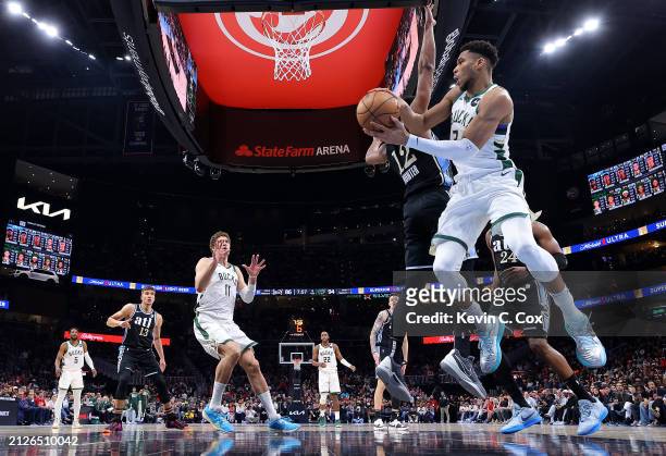 Giannis Antetokounmpo of the Milwaukee Bucks passes the ball as he drives against De'Andre Hunter of the Atlanta Hawks during the fourth quarter at...