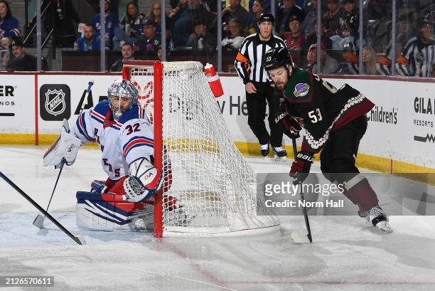 Michael Carcone of the Arizona Coyotes skates with the puck as Jonathan Quick of the New York Rangers looks to make a save at Mullett Arena on March...