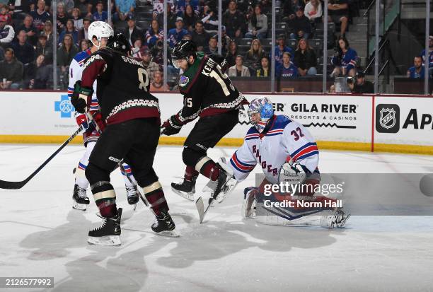 Alex Kerfoot of the Arizona Coyotes attempts to redirect the puck as Jonathan Quick of the New York Rangers makes a save at Mullett Arena on March...