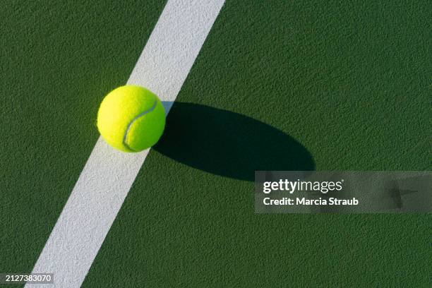 tennis ball on the white line of the court - tennis net stock pictures, royalty-free photos & images