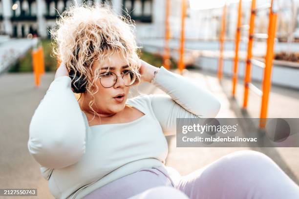 cute overweight woman outdoors training. - weelderig beschrijving stockfoto's en -beelden