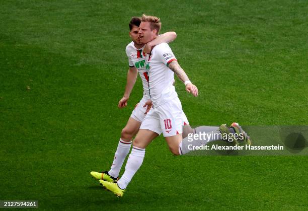 Arne Maier of FC Augsburg celebrates scoring his team's first goal with teammate Elvis Rexhbecaj during the Bundesliga match between FC Augsburg and...