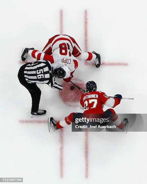 Linesman Julien Fournier drops the puck between Eetu Luostarinen of the Florida Panthers and Andrew Copp of the Detroit Red Wings at the Amerant Bank...