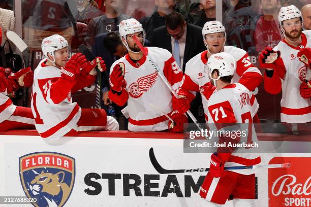 Teammates congratulate Dylan Larkin of the Detroit Red Wings after he scored a third period goal against the Florida Panthers at the Amerant Bank...