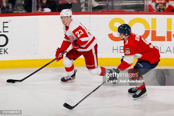 Sam Bennett of the Florida Panthers pursues Lucas Raymond of the Detroit Red Wings at the Amerant Bank Arena on March 30, 2024 in Sunrise, Florida.