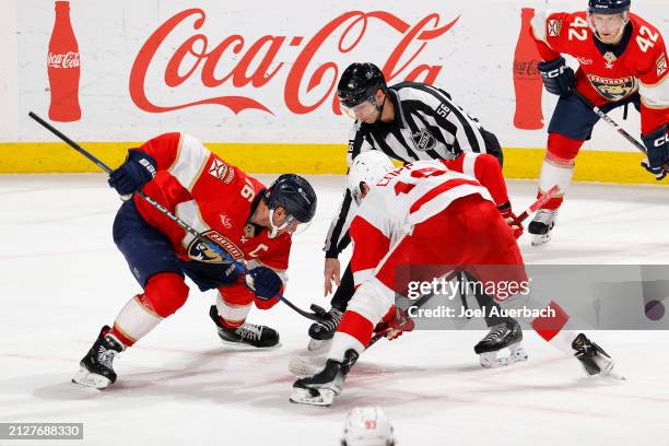 Linesman Julien Fournier drops the puck between Aleksander Barkov of the Florida Panthers and Andrew Copp of the Detroit Red Wings at the Amerant...