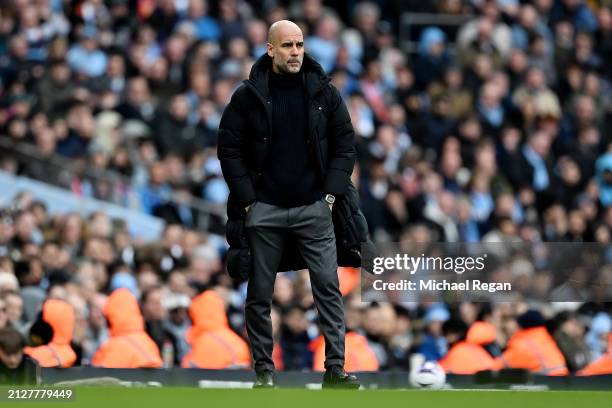 Pep Guardiola, Manager of Manchester City, looks on during the Premier League match between Manchester City and Arsenal FC at Etihad Stadium on March...