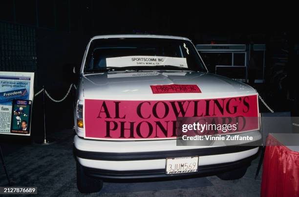 Banner reads 'Al Cowlings's Phone Card' below a smaller sign reading ' AC Speaks Out 1-900-93-ASK-AC' as Cowlings publicises his phone card at an...