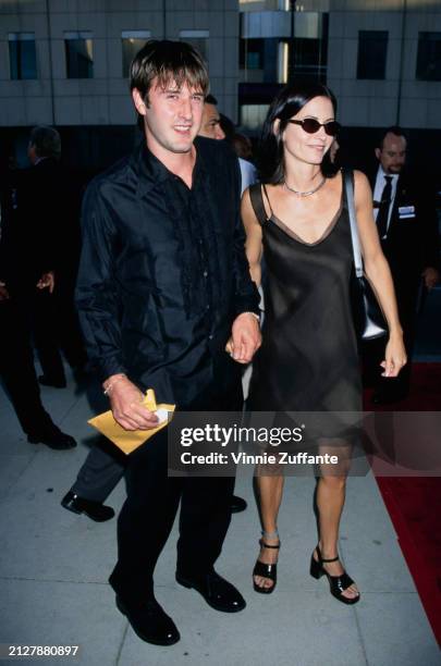 American actor David Arquette, wearing a black shirt and black trousers, and American actress Courteney Cox, who wears a black dress with sunglasses,...