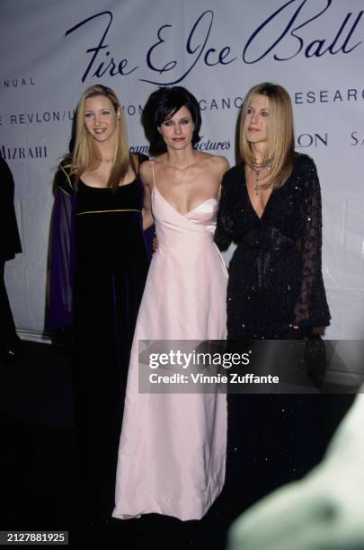 American actress Lisa Kudrow, wearing a black scoop neck evening gown with gold trim, American actress Courteney Cox, who wears a pale pink evening...