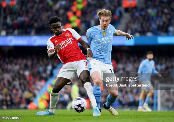 Bukayo Saka of Arsenal battles for possession with Kevin De Bruyne of Manchester City during the Premier League match between Manchester City and...